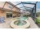 Screened-in pool and spa area with fountains, complemented by a patio and lush landscaping at 223 Heritage Isles Way, Bradenton, FL 34212