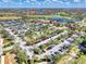 An aerial view showing the community pool, clubhouse, parking and lakes at Sarasota National, under sunny skies at 23703 Waverly Cir, Venice, FL 34293