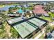 Aerial view of the community clubhouse showing tennis courts, pool, lake, and lush landscaping at 23703 Waverly Cir, Venice, FL 34293