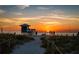 Beach sunset with a lifeguard tower, beachgoers and stunning hues of orange and purple at 23703 Waverly Cir, Venice, FL 34293