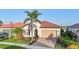 Charming single-story home with a red tile roof, manicured landscaping, and a brick driveway at 23703 Waverly Cir, Venice, FL 34293