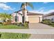 Charming single-story home with a two-car garage, tile roof, and lush tropical landscaping at 23703 Waverly Cir, Venice, FL 34293