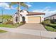 Charming single-story home with a two-car garage, tile roof, and lush tropical landscaping at 23703 Waverly Cir, Venice, FL 34293