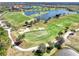 Aerial view of a Sarasota National golf course with lush green fairways, sand traps, and a serene lake at 23703 Waverly Cir, Venice, FL 34293