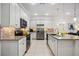 Bright kitchen featuring white cabinetry, granite countertops, stainless steel appliances, and tiled floors at 23703 Waverly Cir, Venice, FL 34293