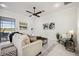 Cozy living room featuring tile flooring, a comfortable sofa, and a stylish ceiling fan at 23703 Waverly Cir, Venice, FL 34293