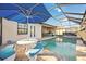 Tranquil pool and outdoor dining area with a large blue umbrella and lake views at 23703 Waverly Cir, Venice, FL 34293