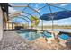 Inviting pool and spa area with a blue umbrella and views of the lake at 23703 Waverly Cir, Venice, FL 34293