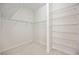 Bright walk-in closet featuring wall-to-wall racks with shelves, and a light wood floor at 23703 Waverly Cir, Venice, FL 34293