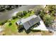 An aerial view shows the property near the water with pool and lush landscaping at 2458 Whippoorwill Cir, Sarasota, FL 34231