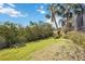 Manicured backyard showing lush greenery, mature trees, and a glimpse of the waterway at 2458 Whippoorwill Cir, Sarasota, FL 34231