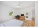 Bedroom with hard wood flooring, ceiling fan, and a large window for natural light at 2458 Whippoorwill Cir, Sarasota, FL 34231