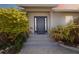 Contemporary home boasts a modern front door, complemented by lush tropical plants at 2458 Whippoorwill Cir, Sarasota, FL 34231