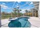 Inviting screened-in pool area with spa, lounge space, and lush tropical surroundings at 2458 Whippoorwill Cir, Sarasota, FL 34231