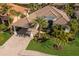 Beautiful home with a tile roof, porte-cochere, lush landscaping, and paver driveway at 579 Fore Dr, Bradenton, FL 34208