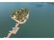 Picturesque aerial view of a charming island with a wooden dock extending into the tranquil lake at 6409 Moorings Point Cir # 102, Lakewood Ranch, FL 34202