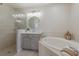 Relaxing bathroom featuring a glass-enclosed shower, soaking tub, and a vanity with traditional-style cabinetry at 6409 Moorings Point Cir # 102, Lakewood Ranch, FL 34202