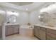 Elegant bathroom featuring a soaking tub, and double vanities with neutral countertops and cabinetry at 6409 Moorings Point Cir # 102, Lakewood Ranch, FL 34202