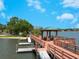A serene dock featuring a covered gazebo, boat slips, and calm water views on a sunny day at 6409 Moorings Point Cir # 102, Lakewood Ranch, FL 34202