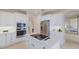 Modern white kitchen features stainless steel appliances, island cooktop, and ample cabinet space at 6409 Moorings Point Cir # 102, Lakewood Ranch, FL 34202