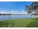 Scenic lake view with lush green lawn and clear blue sky creating a serene outdoor setting at 6409 Moorings Point Cir # 102, Lakewood Ranch, FL 34202