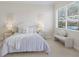 Cozy bedroom with a bench and a large window overlooking the lake at 6409 Moorings Point Cir # 102, Lakewood Ranch, FL 34202