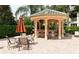 Outdoor bar area with seating and an umbrella shaded table surrounded by landscaping and brick pavers at 6409 Moorings Point Cir # 102, Lakewood Ranch, FL 34202