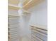 Spacious walk-in closet with adjustable shelving and pull-out storage bins in a neutral color palette at 6409 Moorings Point Cir # 102, Lakewood Ranch, FL 34202