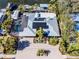 Aerial view of a home with pool, solar panels, lush landscaping, and a brick driveway at 903 20Th W Ave, Palmetto, FL 34221