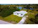 Aerial view of the one-story home with a large yard and a serene lake in the background at 1226 Coral Ridge Dr, Punta Gorda, FL 33950