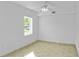 Well-lit bedroom with tile flooring, ceiling fan, and window overlooking the yard at 1226 Coral Ridge Dr, Punta Gorda, FL 33950