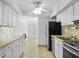 A bright kitchen featuring white cabinetry, tile backsplash, and stainless steel appliances at 1226 Coral Ridge Dr, Punta Gorda, FL 33950