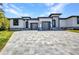 Contemporary home with concrete driveway, modern garage doors, and striking black and white exterior design at 1327 Wesley Dr, Punta Gorda, FL 33950