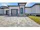 Modern home featuring a textured driveway, minimalist landscaping, and stylish garage doors with matching front door at 1327 Wesley Dr, Punta Gorda, FL 33950