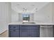 Kitchen island with a large sink, dishwasher, blue cabinets, and serene canal views at 1327 Wesley Dr, Punta Gorda, FL 33950