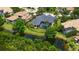 An aerial view of a beautiful home featuring a screened pool and lush landscaping with water view at 13616 Legends Walk Ter, Lakewood Ranch, FL 34202