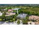 Aerial view of a home with a gray roof, lush landscaping, and a pond in the backyard at 13616 Legends Walk Ter, Lakewood Ranch, FL 34202