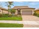 Charming one-story home with a brick driveway, two-car garage, and lush landscaping at 13925 Miranese St, Venice, FL 34293