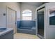 Bathroom featuring a tub, glass-enclosed shower, and unique arched window at 145 Burns Rd, Terra Ceia, FL 34250