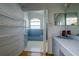 Bathroom with blue tiling, open shelving, vanity, and a unique arched window at 145 Burns Rd, Terra Ceia, FL 34250