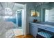 Bathroom with blue accents, vanity area, open shelves, and glass shower at 145 Burns Rd, Terra Ceia, FL 34250