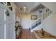 Welcoming foyer with tile flooring, stairway, small sunken tile planter and decorative hanging light fixture at 145 Burns Rd, Terra Ceia, FL 34250