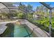 Screened pool and spa overlooking lush landscaping and waterfront view at 1705 Shoreland Dr, Sarasota, FL 34239