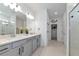 Well-lit bathroom with double sinks, modern fixtures, and a view toward the walk-in closet and water closet at 2930 61St E Dr, Ellenton, FL 34222