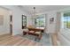 Dining room features a wooden table, bench seating, stylish rug, and a view of the pool at 2930 61St E Dr, Ellenton, FL 34222