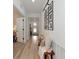 Inviting hallway with light wood floors, decorative bench, and framed Gathering photos on the wall at 2930 61St E Dr, Ellenton, FL 34222