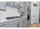 Close-up of kitchen featuring gas cooktop, white backsplash and stainless steel hood at 2930 61St E Dr, Ellenton, FL 34222