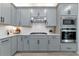 Modern kitchen featuring gray cabinets, stainless steel appliances, and a stylish backsplash at 2930 61St E Dr, Ellenton, FL 34222