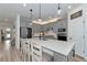 Modern kitchen with an island featuring quartz countertops, pendant lighting, and stainless steel appliances at 2930 61St E Dr, Ellenton, FL 34222