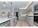 Stylish kitchen with gray cabinets, stainless steel appliances, sleek countertops, and hardwood floors at 2930 61St E Dr, Ellenton, FL 34222